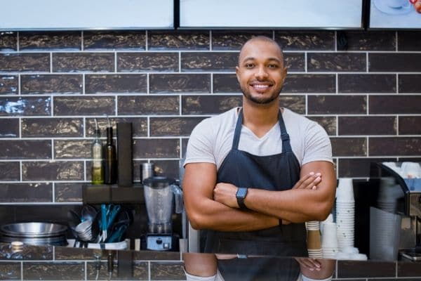 A professional chef smiling in a kitchen.