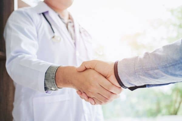 A doctor shaking hands with a patient
