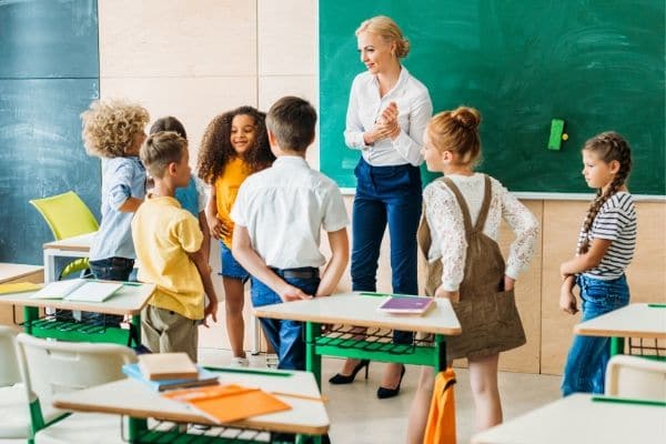 A young woman teachs a class of children.